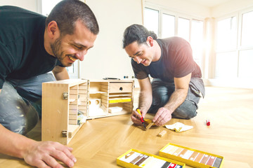 Parkettboden reparatur , zwei handwerker reparieren kratzer im parkettboden.