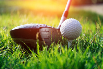 Golf ball and golf club in beautiful golf course at sunset background.