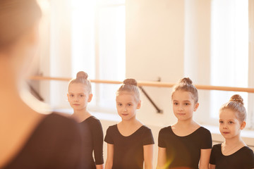 Group of little girls standing in line during ballet class, copy space