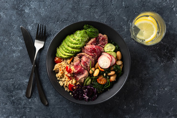 Healthy food buddha bowl with beef steak, beans, couscous, avocado and vegetables