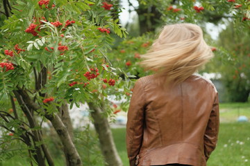 Beautiful blond girl posing for photo in park with wildberry