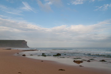 Fototapeta na wymiar Empty beach with yellow sand and mild waves