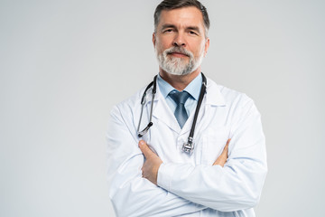 Cheerful mature doctor posing and smiling at camera, healthcare and medicine.