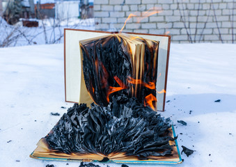 burning book in  snow. pages with the text in  open book burn with  bright flame.