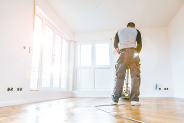 Einölen von Eichenparkett, Arbeiter mit poliermaschine und Werkzeug.