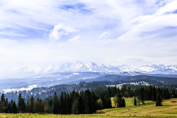 Beautiful landscape of Tatra Mountain covered with snow. View from the green hill.