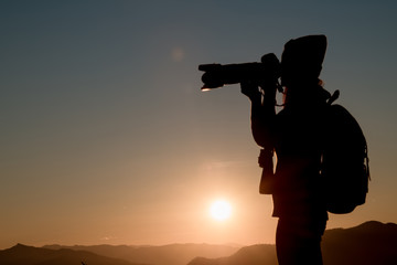 The photographer's silhouette with his camera on a sunset