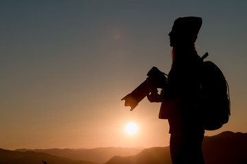 The photographer's silhouette with his camera on a sunset