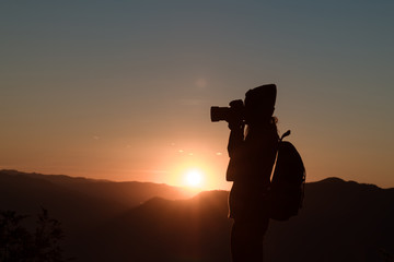 The photographer's silhouette with his camera on a sunset