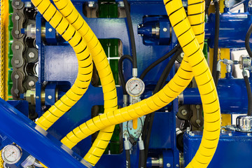 Fragment of powerful drilling equipment. Yellow hydraulic hoses, steel frame, pressure gauge