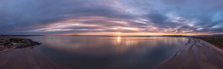Fototapeta na wymiar Sunrise with a moody sky over beach