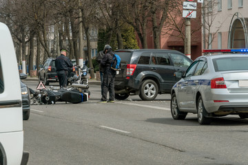 Accident in the city: a broken motorcycle and a car. Registration of a traffic accident. Traffic...