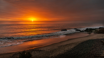 Sunrise with a moody sky over beach