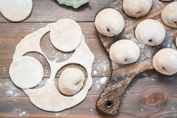 Raw dumplings ready for cooking on a cutting board and cut the dough for making dumplings. Top view. Close-up