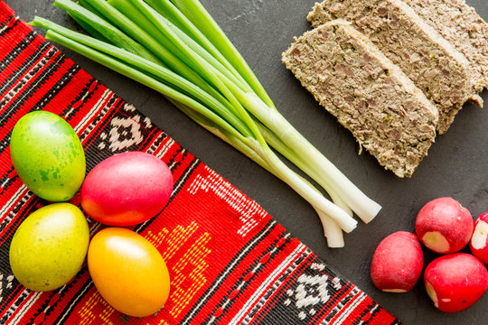 romanian easter food dish lamb tripe stuffed with mincen lamb organs and fresh green onion and radishes and colored easter eggs
