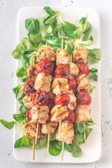 Grilled chicken skewers on the white plate