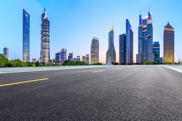 Fototapeta na wymiar Shanghai modern commercial office buildings and empty asphalt road at night,panoramic view