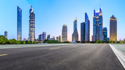 Fototapeta na wymiar Shanghai modern commercial office buildings and empty asphalt road at night,panoramic view