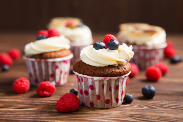 Homemade cupcakes with berries on a wooden background