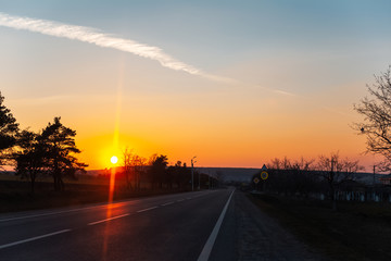 Landscape of unreal natural sunset on road from inside of car.