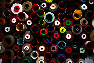 Dark background of colored thread coils for sewing