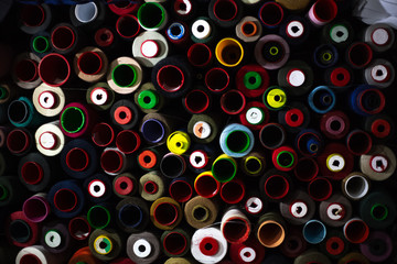 Dark background of colored thread coils for sewing