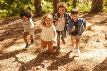 Kids running up in the forest - Powered by Adobe