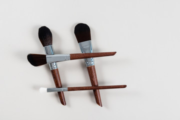 Professional Makeup brushes in shape of hashtag. Cosmetic social medea content. Visagist, copy space