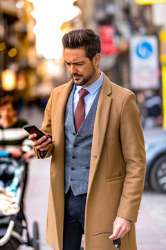 A handsome elegant man using his smartphone