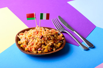 Quinoa dish with vegetable and cherry tomatoes, chopping board