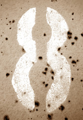 Number 8 in stencil on grungy metal wall in brown tone.