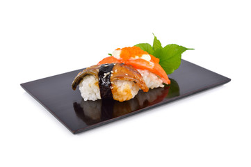 Sushi nigiri and sashimi served on flat black plate with white background