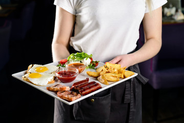 Obraz na płótnie Canvas Waitress serving breakfast at a restaurant
