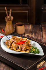 Braise pig's large intestines in soy sauce in a white ceramic dish