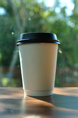 take away cup for hot coffee drink put on wooden table in cafe