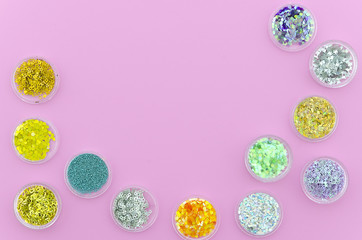 Flat lay framed Multi-colored Sequins for the design of nails in a Jar. Glitter in jars. Top view with copy space in the middle