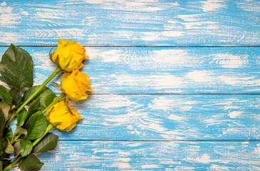 Fototapeta na wymiar A bouquet of yellow roses lies on a bluewooden background 
