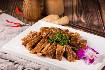 Baked smoked duck meat slices in the white ceramic dish