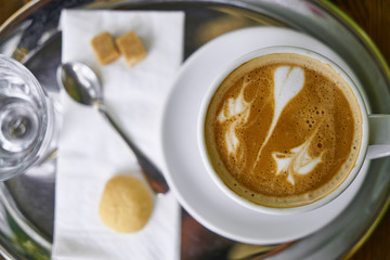 Cup of hot coffee latte on a wooden table