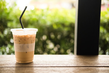 Iced espresso on the wooden table with nature light background
