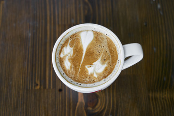 Cup of hot coffee latte on a wooden table