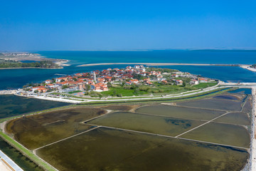 Fototapeta na wymiar Aerial view of city of Nin. Summer time in Dalmatia region of Croatia. Coastline and turquoise water and blue sky with clouds. Photo made by drone from above.
