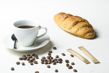 Coffee and fresh croissant on wooden background