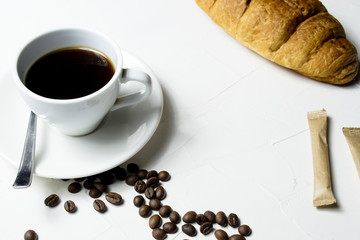 Coffee and fresh croissant on wooden background