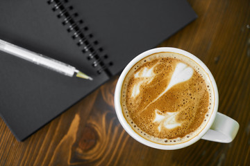 Cup of hot coffee latte on a wooden table