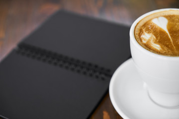 Cup of hot coffee latte on a wooden table