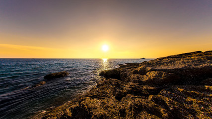 Obraz premium Sunset on the rocks of Surin beach, Phuket, Thailand