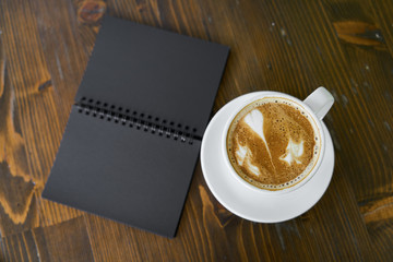 Cup of hot coffee latte on a wooden table