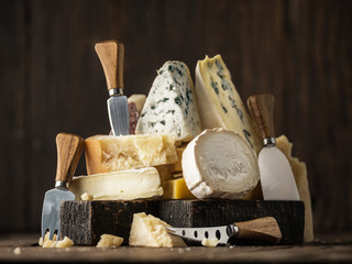 Fototapeta Assortment of different cheese types on wooden background. Cheese background. obraz