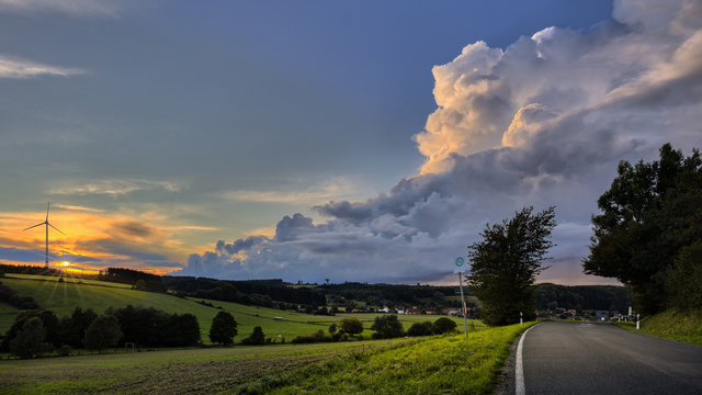 A view in spring over Veldrom after a thunderstorm and hailstorm with a wind turbine in the field.